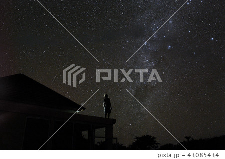 alone woman on rooftop watching mliky way and stars in the night sky on Bali island alone woman on rooftop watching mliky way and stars in the night sky on Bali island 43085434