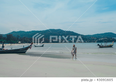 handsome girl on the beach background. Portrait of a woman in white clothes on the sea 43091605