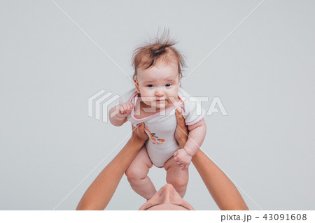 Dad raised his daughter in his arms on a white background. Girl in fly 43091608
