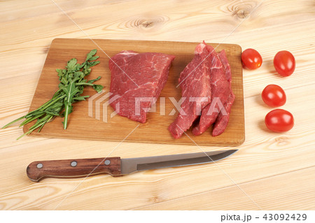 Sliced raw beef on cutting board and vegetables 43092429
