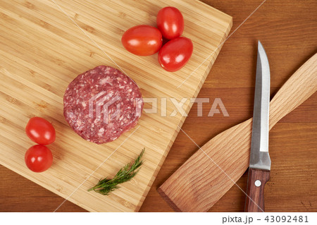 Raw cutlet of minced meat on a wooden cutting board. Raw cutlet of minced meat on a wooden cutting board. 43092481