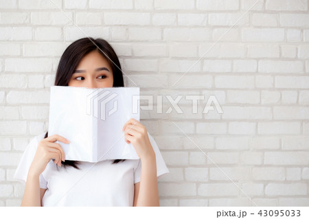 beautiful portrait asian woman hiding behind book 43095033