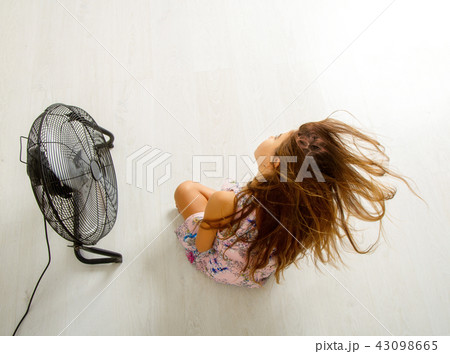 the girl is sitting in front of the fan the girl is sitting in front of the fan 43098665