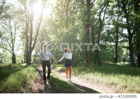 young couple walking in the forest, summer nature 43100090
