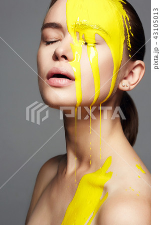 Young woman in Yellow paint. liquid paint flowing Young woman in Yellow paint. liquid paint flowing 43105013