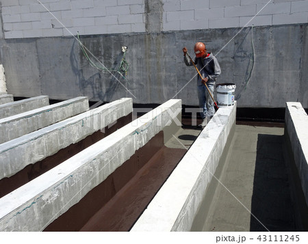 Waterproofing layer applied by construction worker 43111245