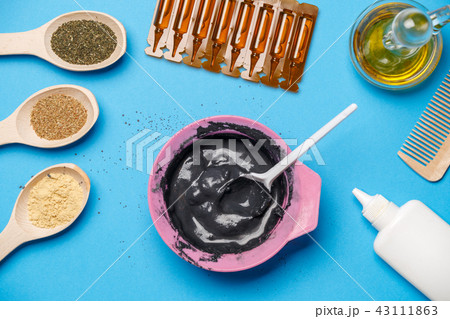 Photo from above with pink cup with black clay, mask oils, wooden spoons, combs, with spoon Photo from above with pink cup with black clay, mask oils, wooden spoons, combs, with spoon 43111863