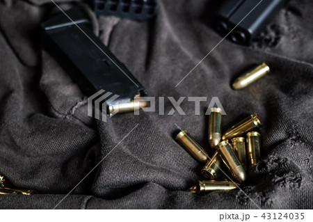 9mm autometic hand gun with FMJ bullet on fabric 43124035