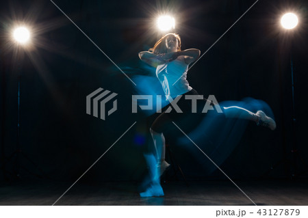 Dancing, sport, beautiful and people concept - young woman dancing in darkness jumped in colourful Dancing, sport, beautiful and people concept - young woman dancing in darkness jumped in colourful 43127879