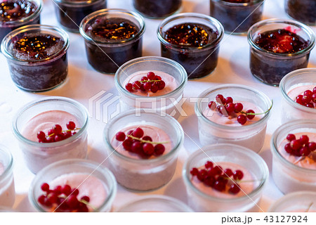 Closeup many dessert jar rowed up on buffet table with fresh fruits jelly and cream Closeup many dessert jar rowed up on buffet table with fresh fruits jelly and cream 43127924