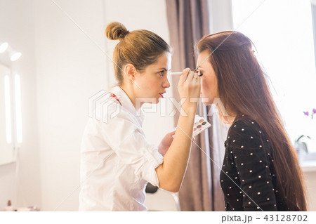 Make up artist doing professional make up of young woman Make up artist doing professional make up of young woman 43128702