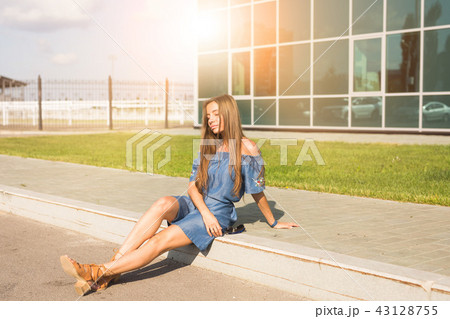 Lifestyle, fashion and people concept - Portrait of a beautiful young woman with long hair sitting 43128755