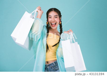 Happy young woman in raincoat with shopping bags Happy young woman in raincoat with shopping bags 43131394