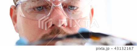 A male repairman wearing blue gloves 43132167