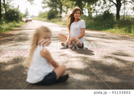 little girl playing with mom in the park in summer day during the sunset 43133603