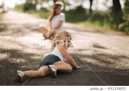little girl playing with mom in the park in summer day during the sunset 43133605