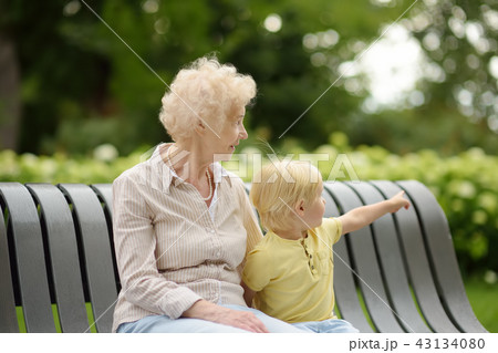 Beautiful granny and her little grandson walking together in park 43134080
