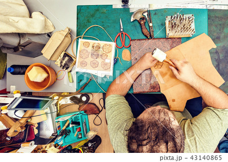 Leather artisan craftsman drawing an ornament Leather artisan craftsman drawing an ornament 43140865