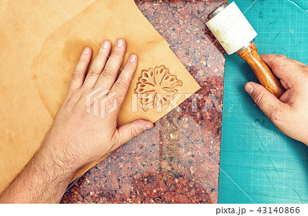 Leather artisan craftsman drawing an ornament Leather artisan craftsman drawing an ornament 43140866