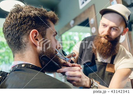 Close-up of the head of a young man and the hands of a hairstylist 43142341