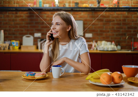 Beautiful young woman having breakfast Beautiful young woman having breakfast 43142342