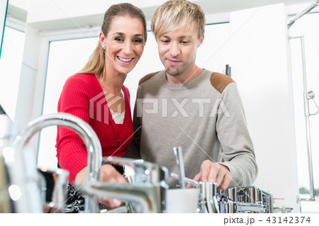 Happy couple choosing a new faucet in a modern sanitary ware shop 43142374
