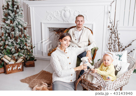 Loving family Merry Christmas and Happy New Year. Cheerful pretty people. Mom, dad and little Loving family Merry Christmas and Happy New Year. Cheerful pretty people. Mom, dad and little 43143940