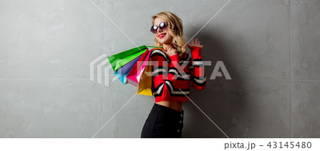 girl in red striped sweater with shopping bags girl in red striped sweater with shopping bags 43145480