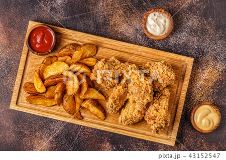Fried chicken wings with fried potato slices. Fried chicken wings with fried potato slices. 43152547