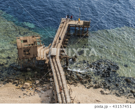 Beautiful top view of blue sea with long wood pier Beautiful top view of blue sea with long wood pier 43157451