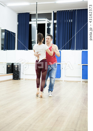 Atractive young man and woman dancing in big studio hall 43162373