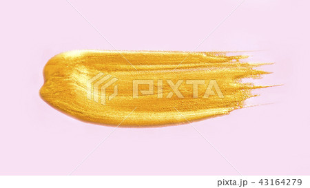 Golden cosmetic liquid smear on pink background. Golden cosmetic liquid smear on pink background. 43164279