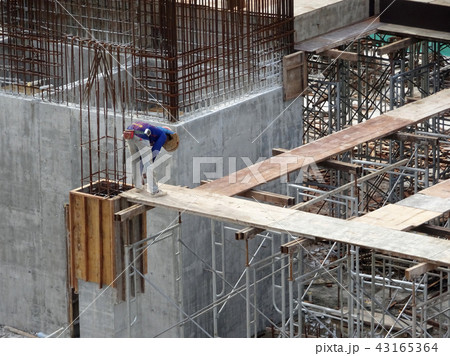 Construction workers fabricating timber form work. 43165364