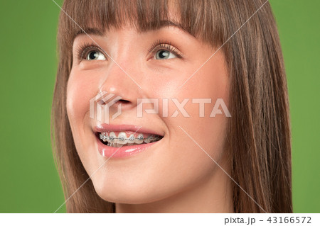 Beautiful young woman with teeth braces 43166572