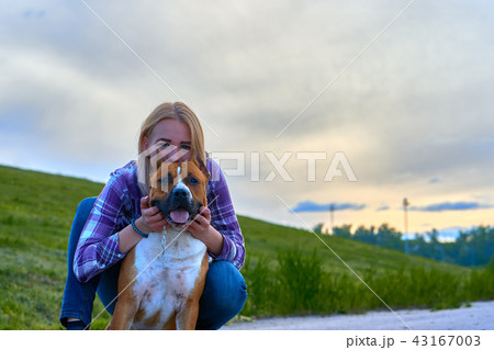 Blond girl on an evening walk with a dog.  43167003