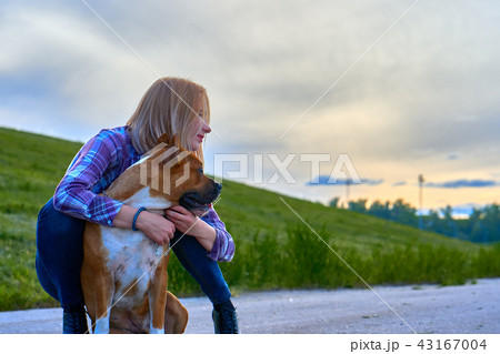 Blond girl on an evening walk with a dog.  43167004