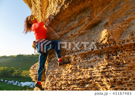 Pcture of curly-haired climber girl climbing rock Pcture of curly-haired climber girl climbing rock 43167483