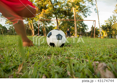 Boy kicking soccer ball on sports field.  43174744