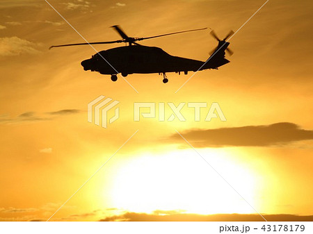 茜色に染まる美しい夕空を飛行する海上自衛隊のSH-60Kシーホーク対潜哨戒ヘリコプター 43178179