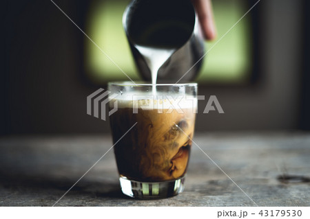 Black coffee in glass And milk is pouring Black coffee in glass And milk is pouring 43179530