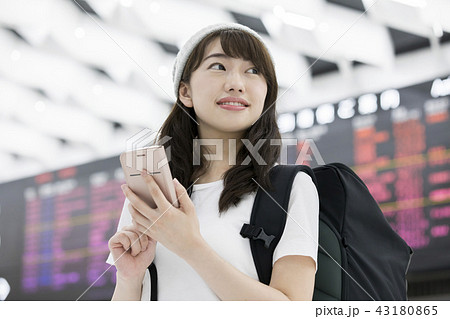 空港内でスマホを操作するバックパッカー女性 43180865