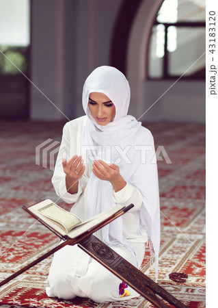 Young muslim woman praying in mosque with quran 43183120
