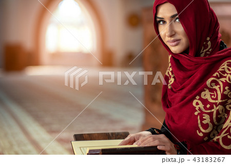 Young muslim woman praying in mosque with quran 43183267