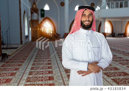 smiling young arabian man posing inside the mosque smiling young arabian man posing inside the mosque 43183834