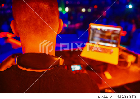 Club, disco DJ playing and mixing music for crowd of happy people. Nightlife, concert lights, flares Club, disco DJ playing and mixing music for crowd of happy people. Nightlife, concert lights, flares 43183888