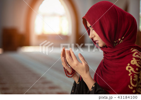Young muslim woman praying in mosque with quran 43184100