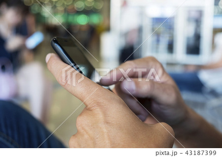man using smartphone in a station or airport 43187399