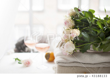 Two glasses of wine and a lot of winter warm clothes at home near the window. Cat, large bouquet of Two glasses of wine and a lot of winter warm clothes at home near the window. Cat, large bouquet of 43188133