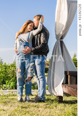 Family, pregnancy and people concept - Pregnant woman with husband in nature Family, pregnancy and people concept - Pregnant woman with husband in nature 43192120