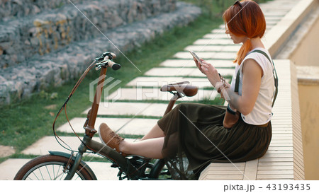 Redhaired woman cyclist making selfie on mobile phone with bike. Woman bicycling 43193435